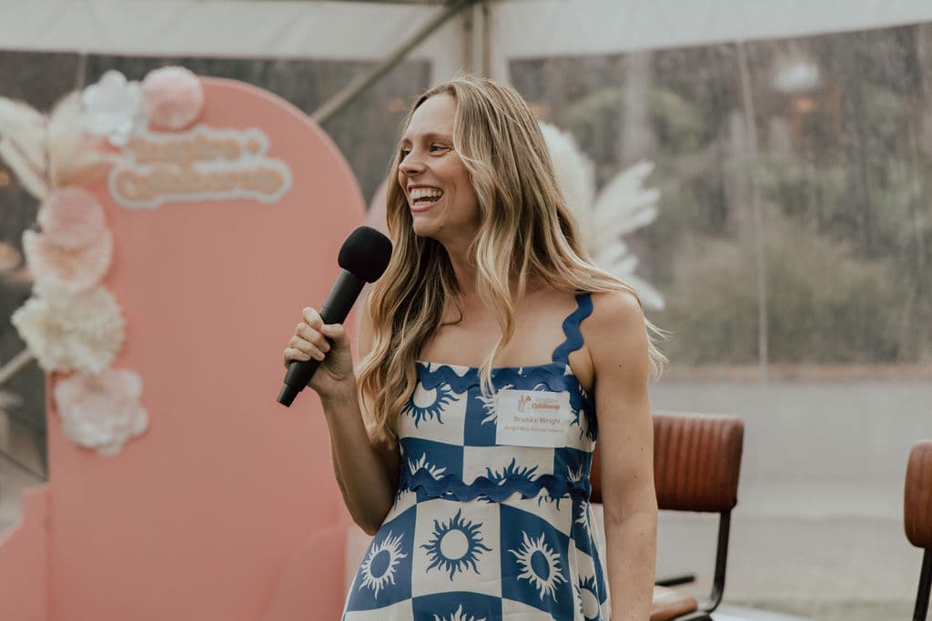 Brooke Wright speaking on stage with a microphone